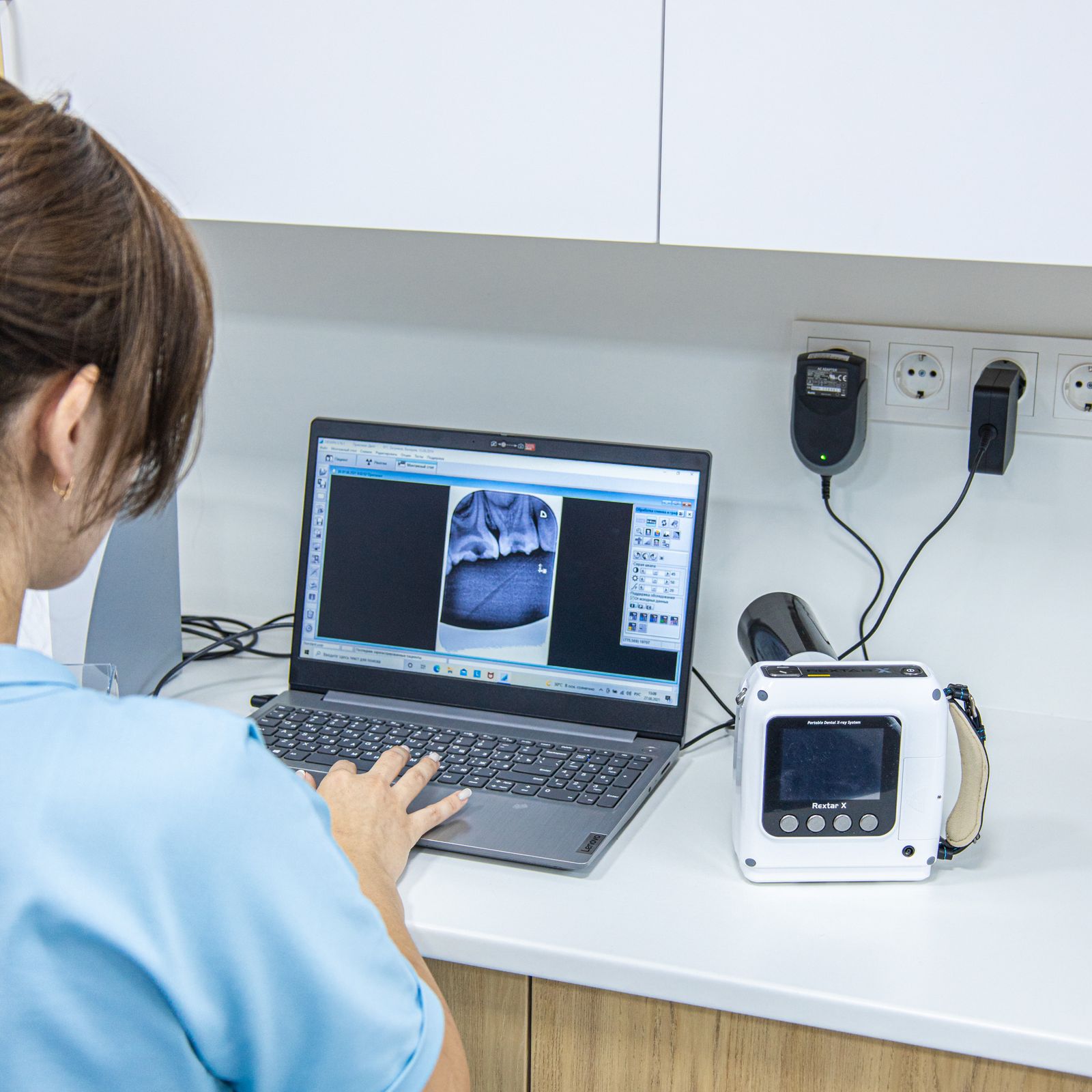 Dentista trabalhando em laptop com prontuário digital
